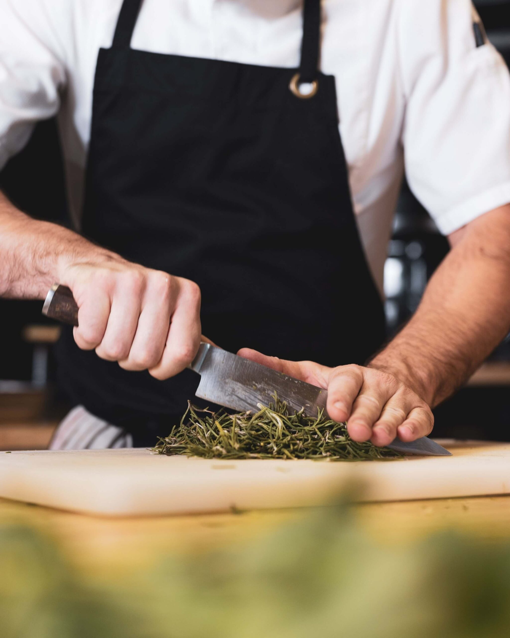 chef en train de découper des ingrédients pour les participants d'un cours de cuisine à montpellier